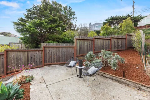 a view of a backyard with a patio and potted plants