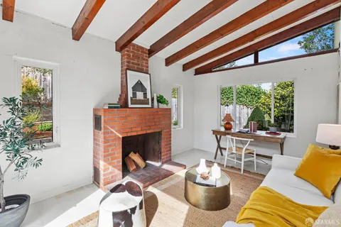 a living room with furniture fireplace and a large window