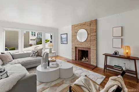 a living room with furniture a fireplace and a large window