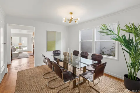 a view of a dining room with furniture and a potted plant