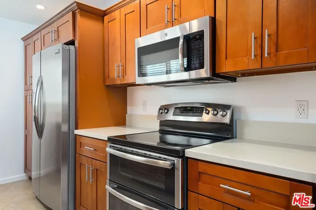 a kitchen with stainless steel appliances granite countertop a refrigerator and a stove