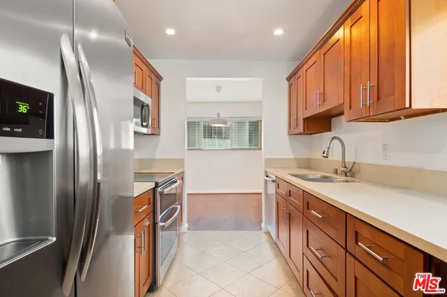 a kitchen with stainless steel appliances granite countertop a refrigerator and a sink