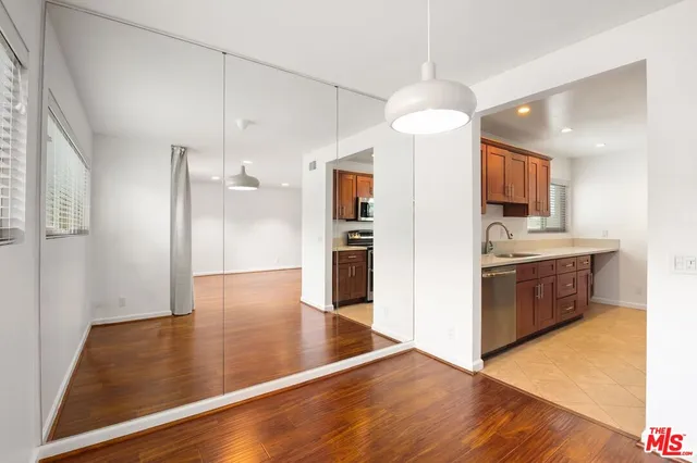 a view of kitchen with refrigerator stove and wooden floor