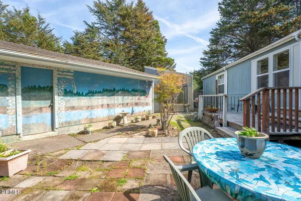 a view of a patio with table and chairs and wooden fence