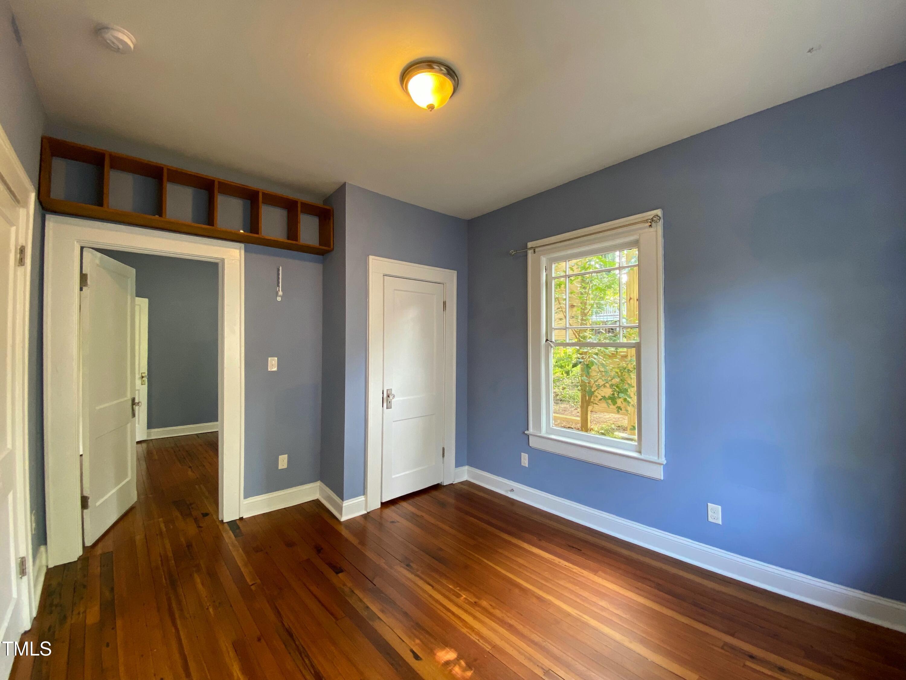 407 Ottawa Avenue Durham, NC 27701 - Photo 14 of 32 a view of an empty room with wooden floor and a window