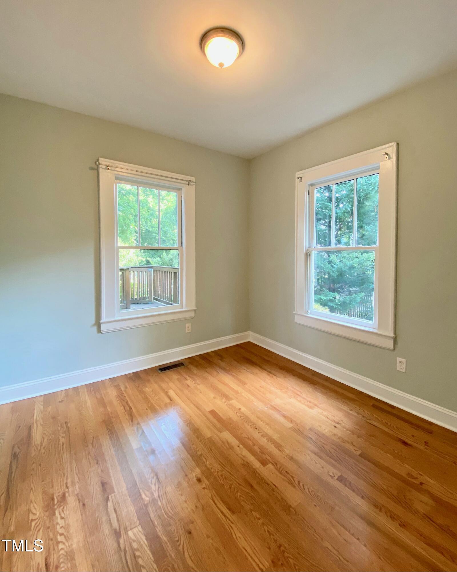 407 Ottawa Avenue Durham, NC 27701 - Photo 20 of 32 a view of an empty room with wooden floor and a window