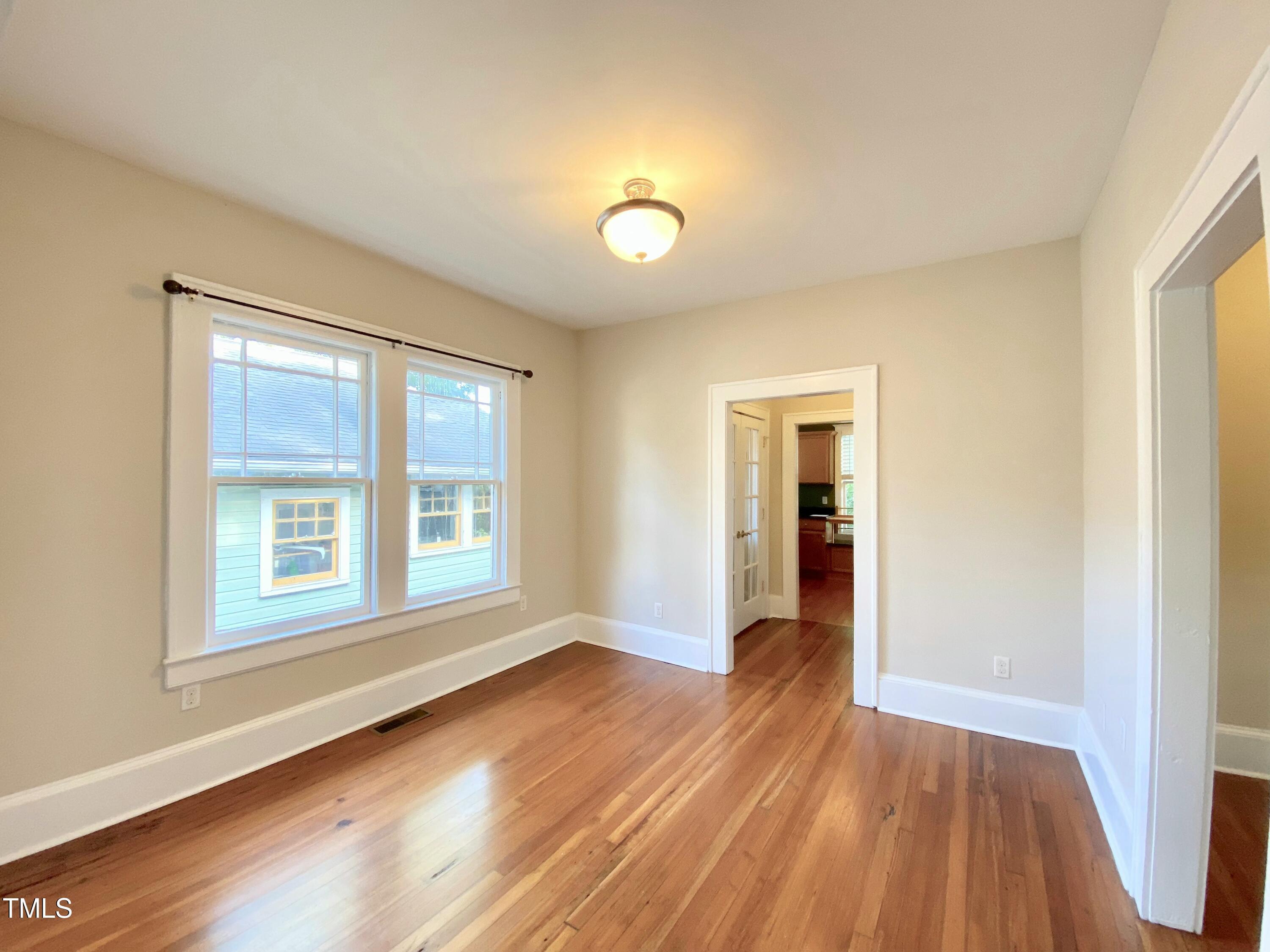 407 Ottawa Avenue Durham, NC 27701 - Photo 5 of 32 a view of an empty room with wooden floor and a window