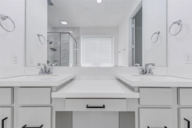 a bathroom with a bathtub double vanity sink and a shower