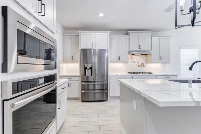 a kitchen with a refrigerator sink and oven