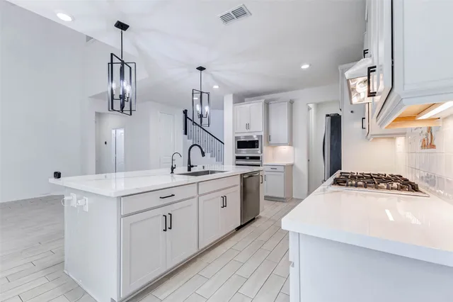 a kitchen with granite countertop a sink stove and refrigerator