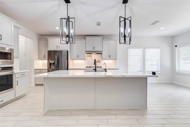 a kitchen with stainless steel appliances a sink and a refrigerator