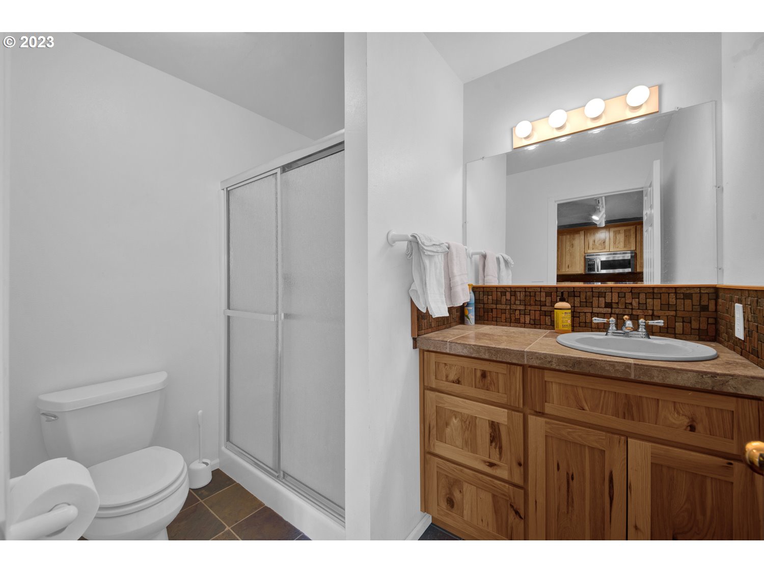 67100 Fryrear Road Bend, OR 97703 - Photo 32 of 37 a bathroom with a toilet a sink a vanity and mirror