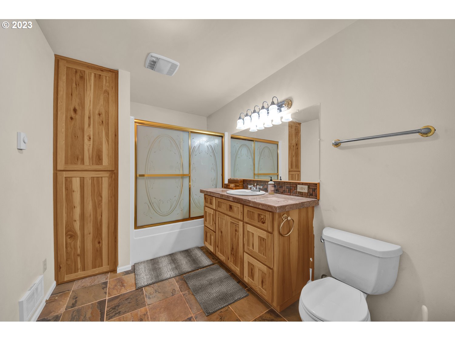 67100 Fryrear Road Bend, OR 97703 - Photo 34 of 37 a bathroom with a granite countertop sink a toilet a mirror and shower