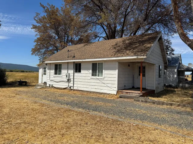 a white house that has a tree in front of it