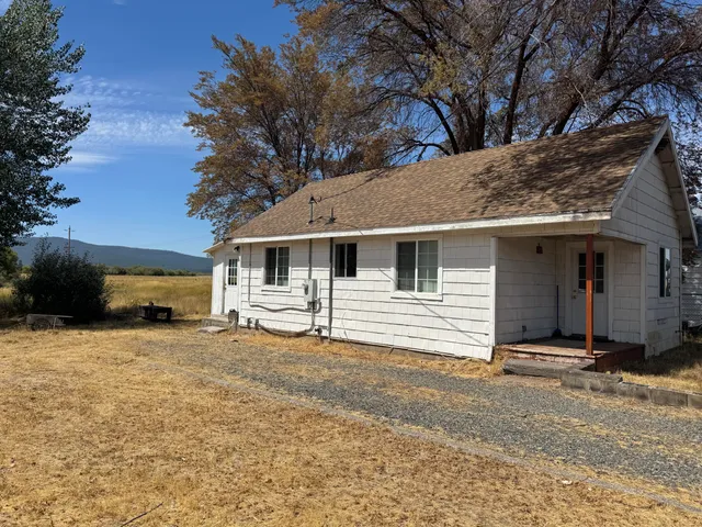 a view of a house with a yard covered in snow