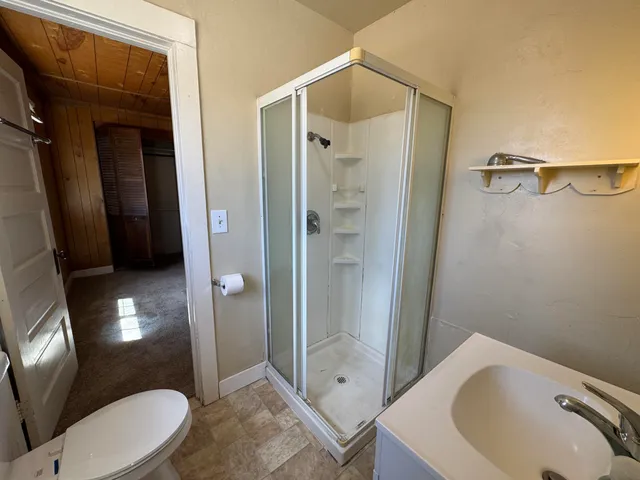 a bathroom with a sink a toilet and shower