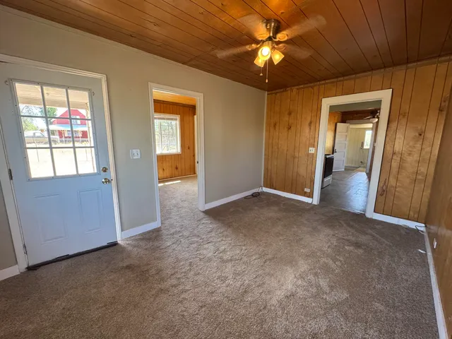 an empty room with fan and windows