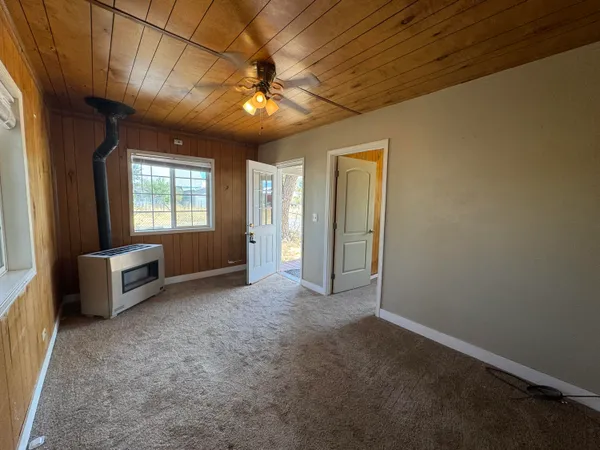 en empty room with windows and ceiling fan