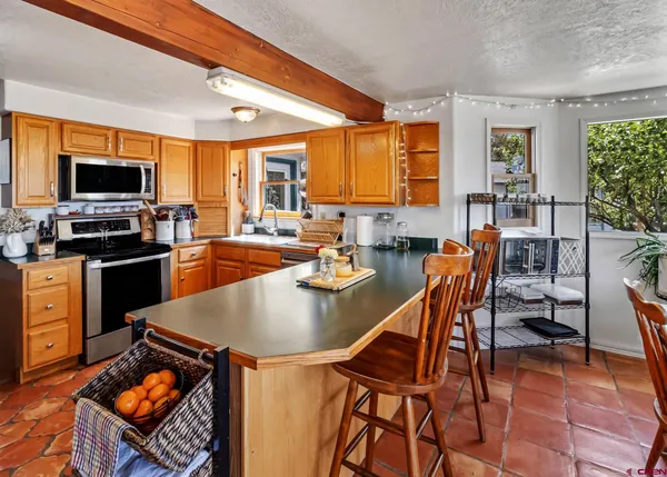a large kitchen with a table chairs and flat screen tv