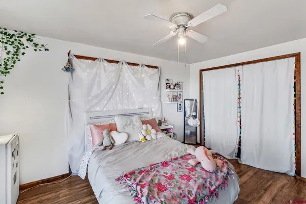 a bedroom with a bed and a table with wooden floor