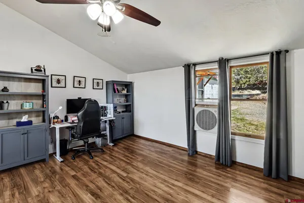 a view of a workspace with furniture and a window