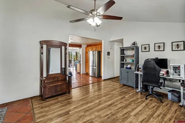a view of a workspace with furniture and a chandelier fan