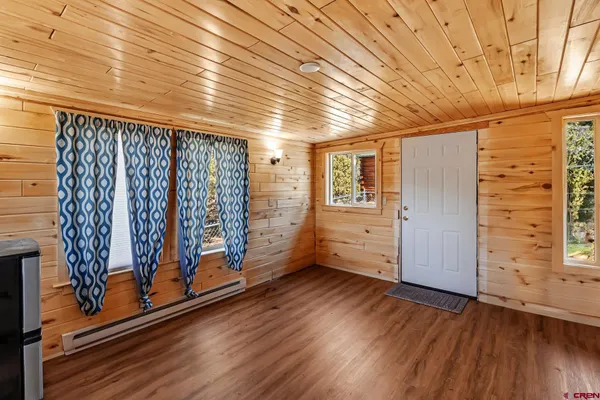a view of a room with wooden floor and door