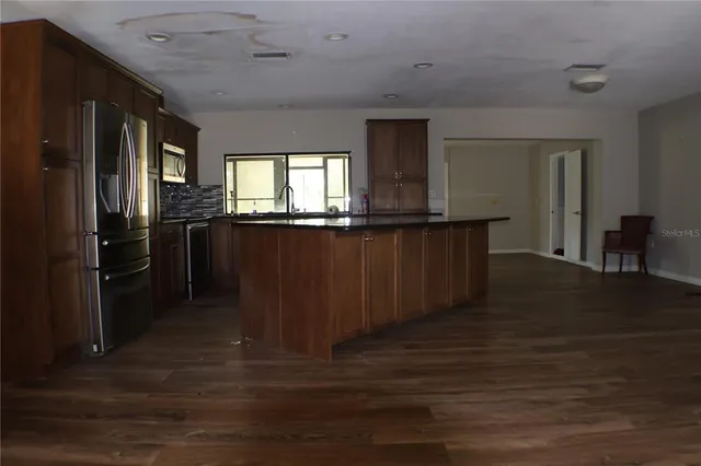 a kitchen with stainless steel appliances wooden floors wooden cabinets and sink