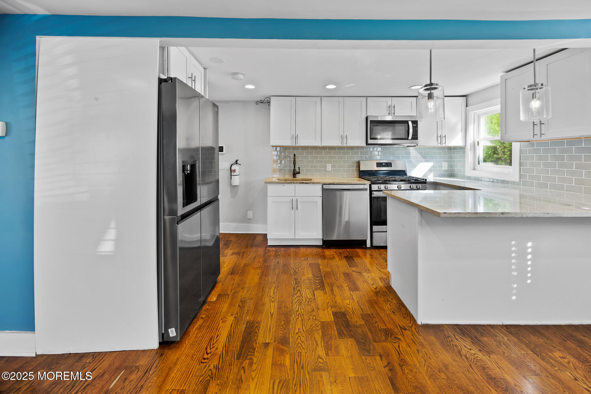 605 Ocean Gate Avenue Ocean Gate, NJ 08740 - Photo 13 of 45 a kitchen with stainless steel appliances granite countertop a refrigerator a sink dishwasher a stove and white countertops with wooden floor