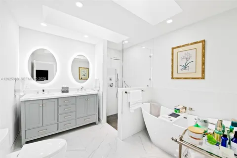 a spacious bathroom with a double vanity sink mirror and bathtub