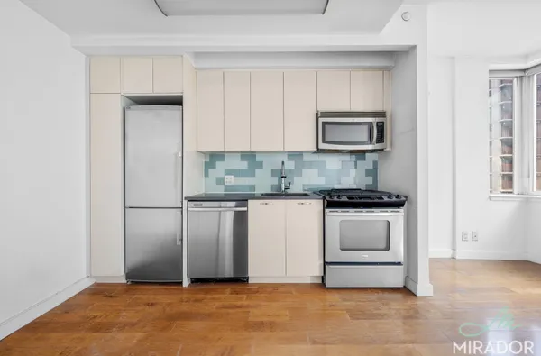 a kitchen with white cabinets and stainless steel appliances