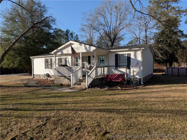 a view of a house with a large tree in front of it