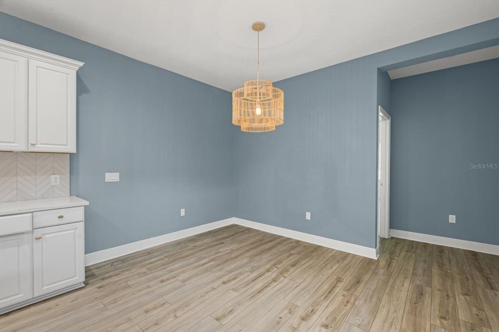 4457 Sage Grn Terrace Sarasota, FL 34243 - Photo 17 of 51 a view of a room with wooden floor and white walls