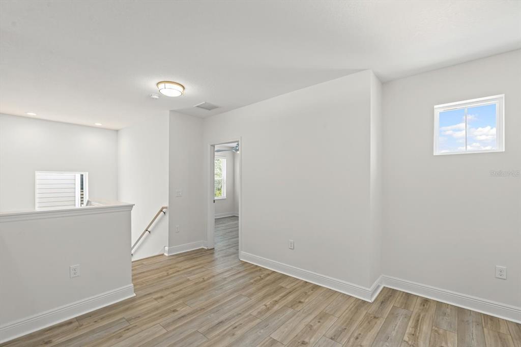4457 Sage Grn Terrace Sarasota, FL 34243 - Photo 36 of 51 an empty room with wooden floor and windows