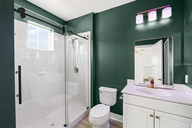 a bathroom with a sink a toilet and shower