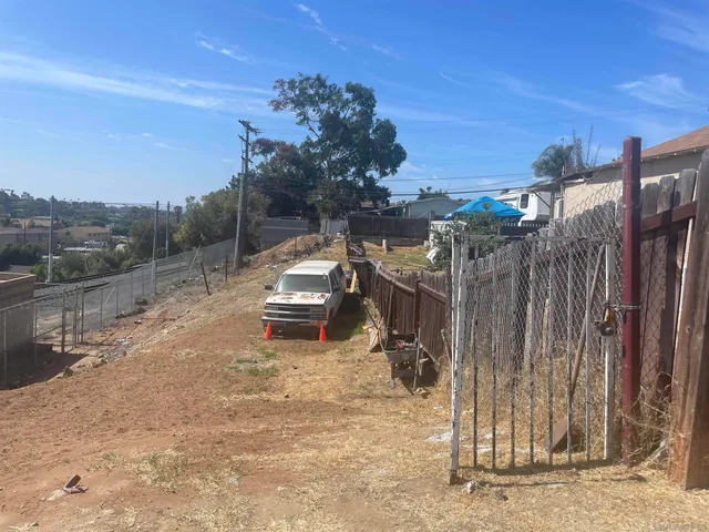 a view of a backyard with wooden fence