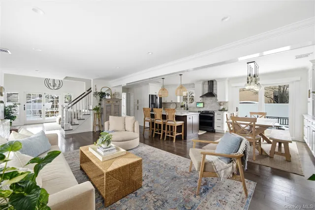 a living room with furniture and a dining table with wooden floor