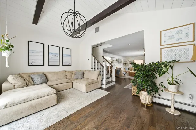 a living room with furniture stairs and a potted plant