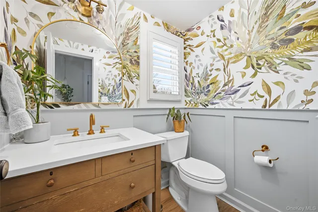 a bathroom with a sink a toilet and a mirror