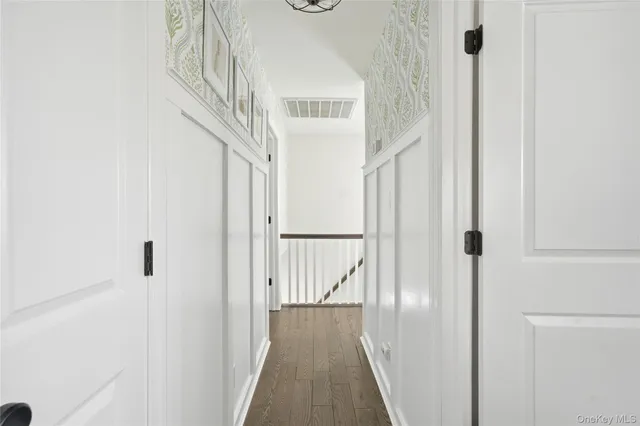 a view of a hallway with wooden floor and entryway