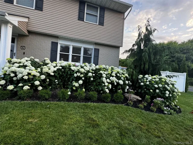 a front view of a house with a garden