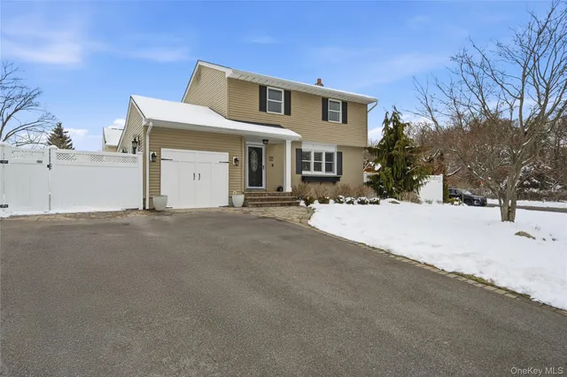 a front view of a house with a snow on the road