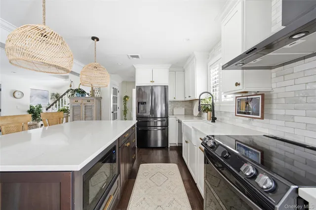a large kitchen with stainless steel appliances granite countertop a lot of counter space and wooden floor