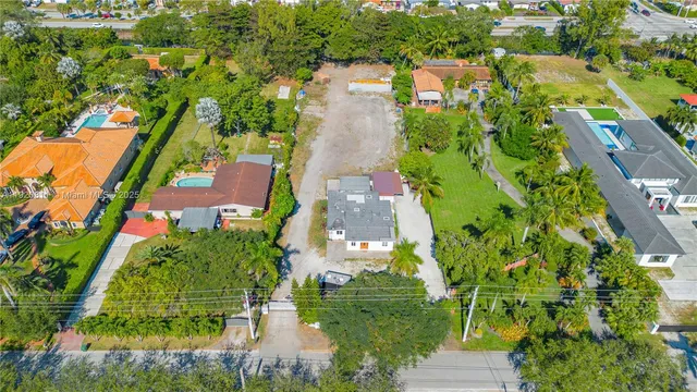 an aerial view of residential houses with outdoor space and trees all around