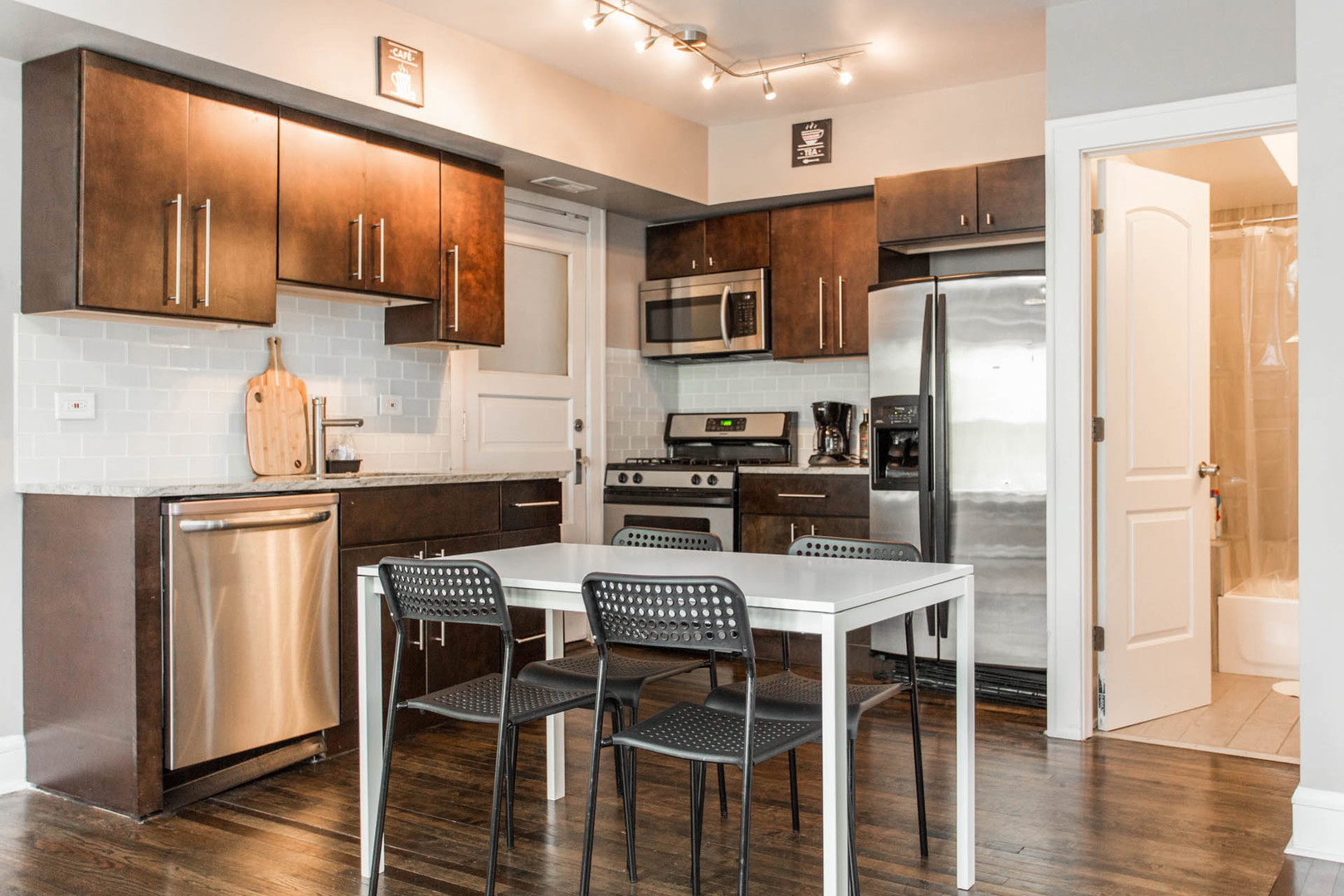 4136 West Palmer Street Chicago, IL 60639 - Photo 22 of 35 a kitchen with stainless steel appliances granite countertop a refrigerator a stove a sink a dining table and chairs with wooden floor