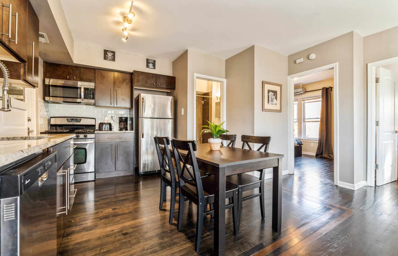 4136 West Palmer Street Chicago, IL 60639 - Photo 8 of 35 a kitchen with granite countertop a refrigerator a stove a dining table and chairs with wooden floor