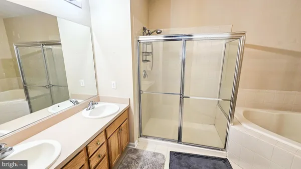 a bathroom with a tub sink vanity and mirror