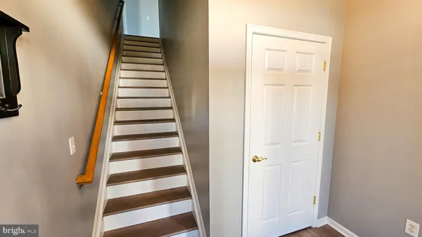 a view of a hallway with wooden floor and entryway