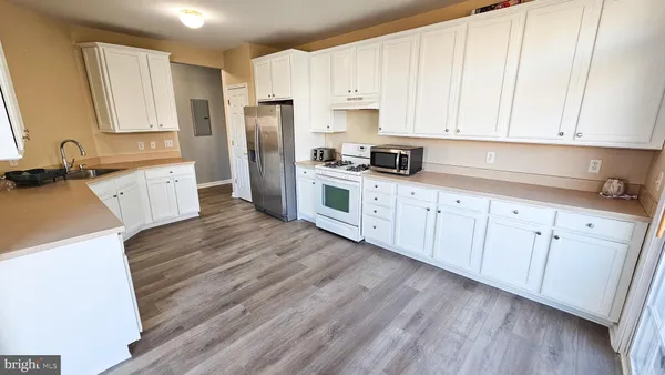 a kitchen with granite countertop white cabinets and white appliances