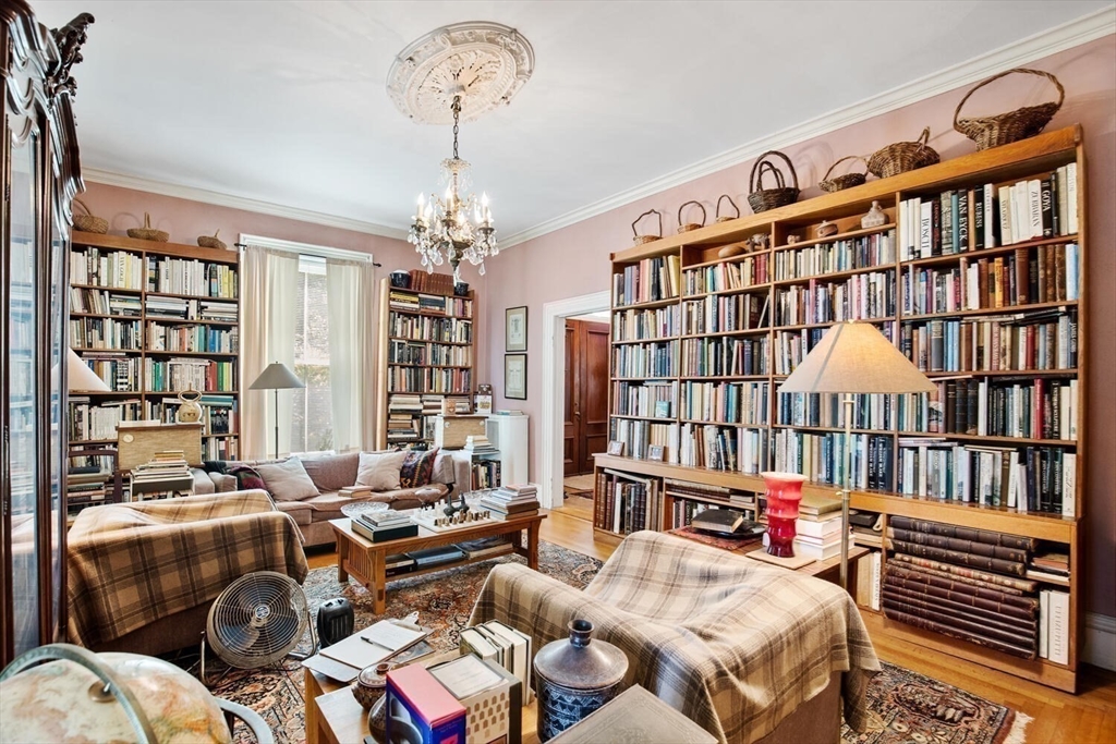 41 Dearborn Street Salem, MA 01970 - Photo 11 of 37 a living room with furniture a chandelier and a bookshelf